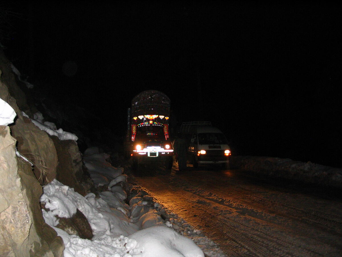 Vehicles crossing an icy mountain pass at night