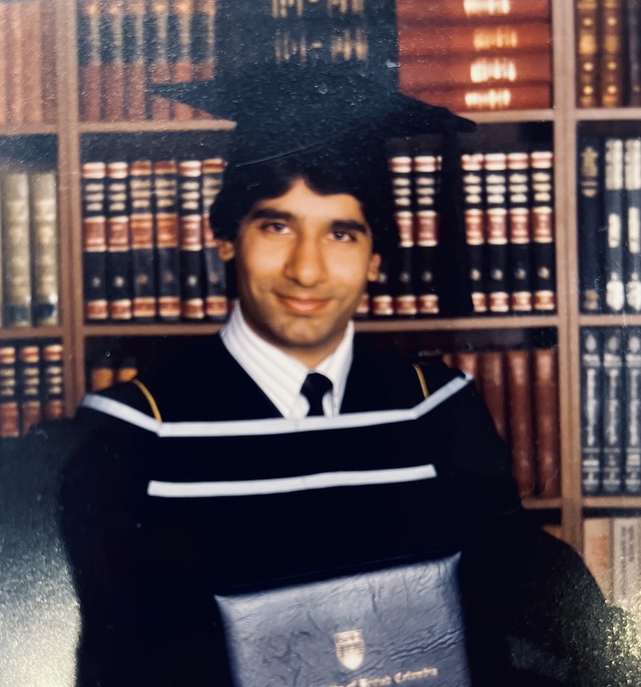 Rahim Abdulla in his UBC pharmacy graduation gown, holding his diploma