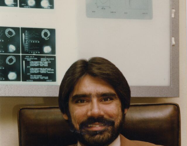 Dr. Abdulla in his office with nuclear cardiology scan results on the wall, Lancaster, California