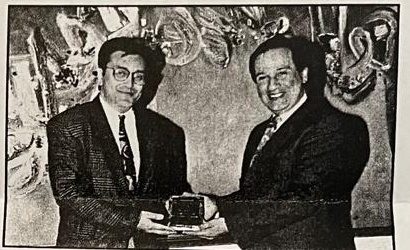 Al-Karim Haji, on behalf of the Canadian youths, presents a plaque to Huzur Mukhi Nizam Abdulla, Vice President of the National Council for the United Kingdom, London, 1992